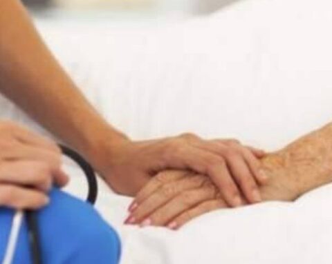 operatore sanitario accanto al letto di un paziente