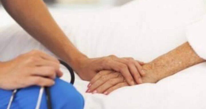 operatore sanitario accanto al letto di un paziente
